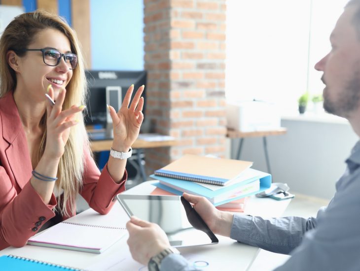 Two adult business people make work interview against office background